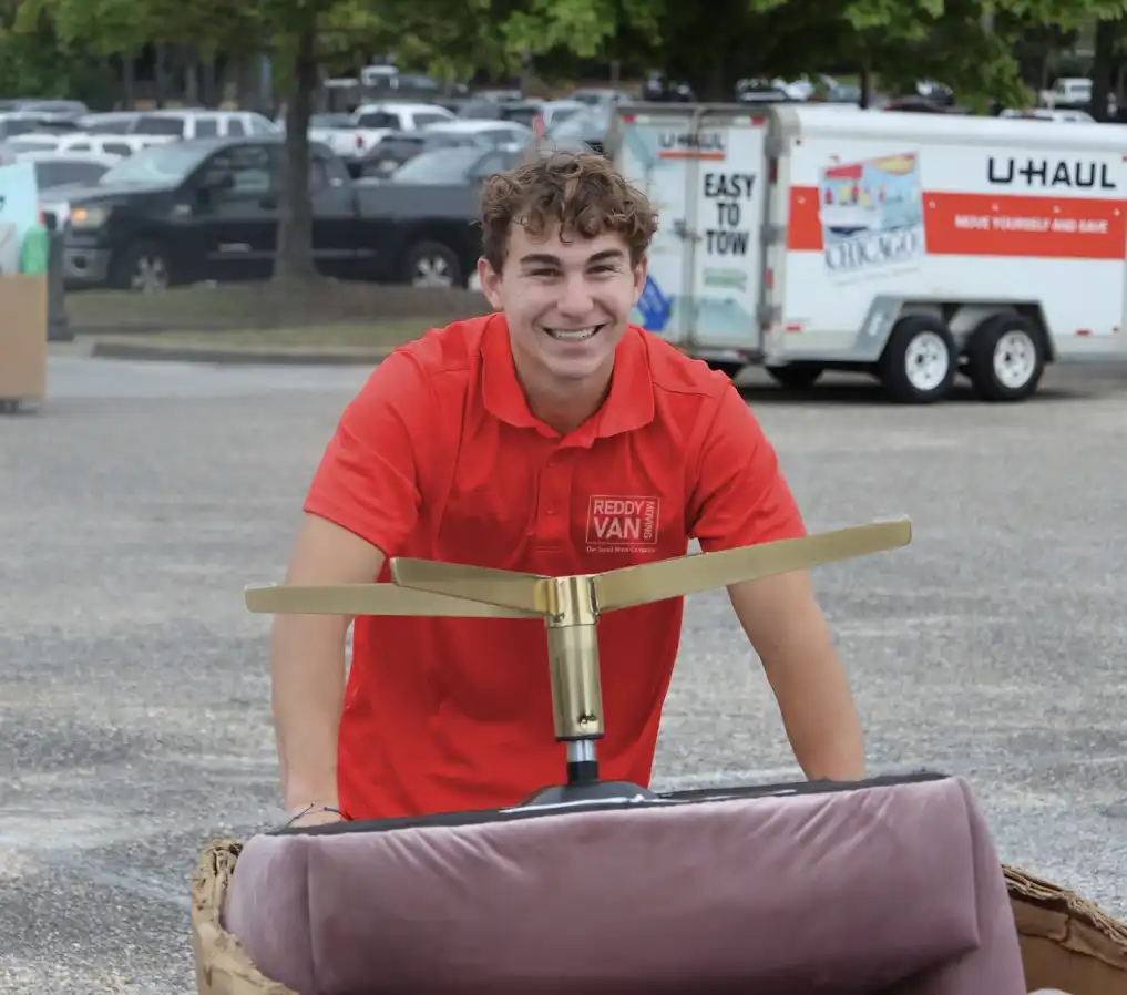Friendly college student movers team wearing red uniforms and preparing for a move.